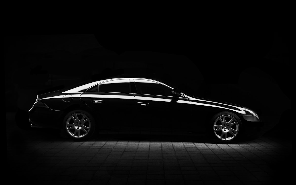 Black coupe silhouette traced by light in a dark studio