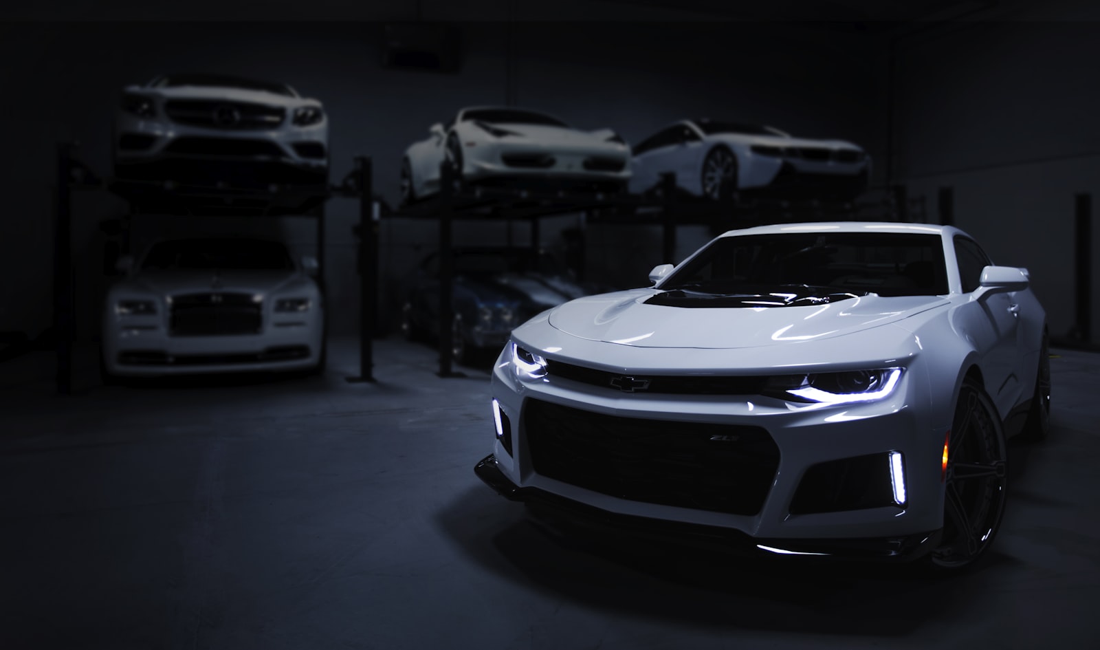 Cars on lifts in a dark private collection garage